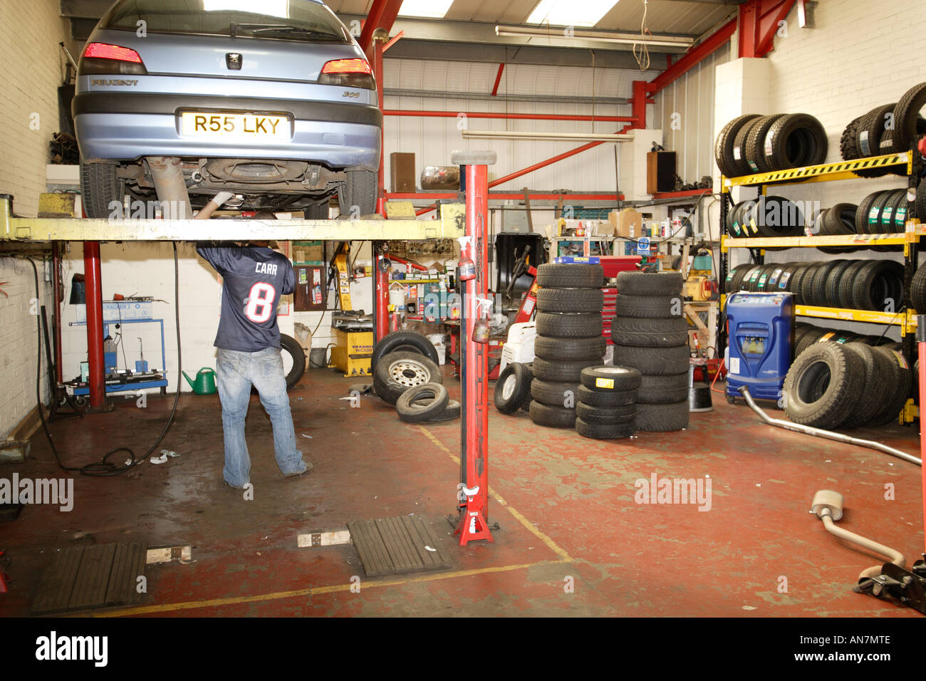 Bergfahrt auf Hebebühne in einer Garage Mechaniker arbeiten unter Fahrzeug  Stockfotografie - Alamy