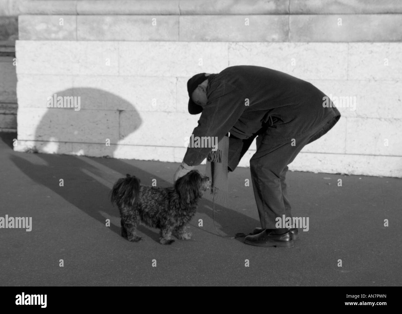 Älterer Mann dazu neigt, seinen Hund auf Pont Alexandre III Paris Frankreich Stockfoto