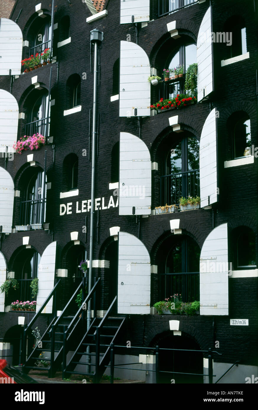 Blumenkästen schmücken die bemalten Fassaden von hohen Gebäuden im Zentrum von Amsterdam Stockfoto