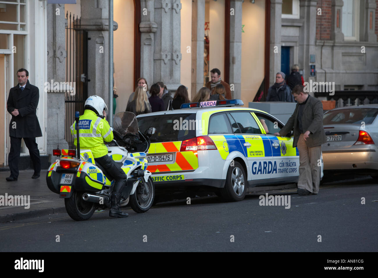 Mann im Gespräch mit Gardasee Verkehr Korps Streifenwagen und Polizei Motorrad Dublin Irland Stockfoto