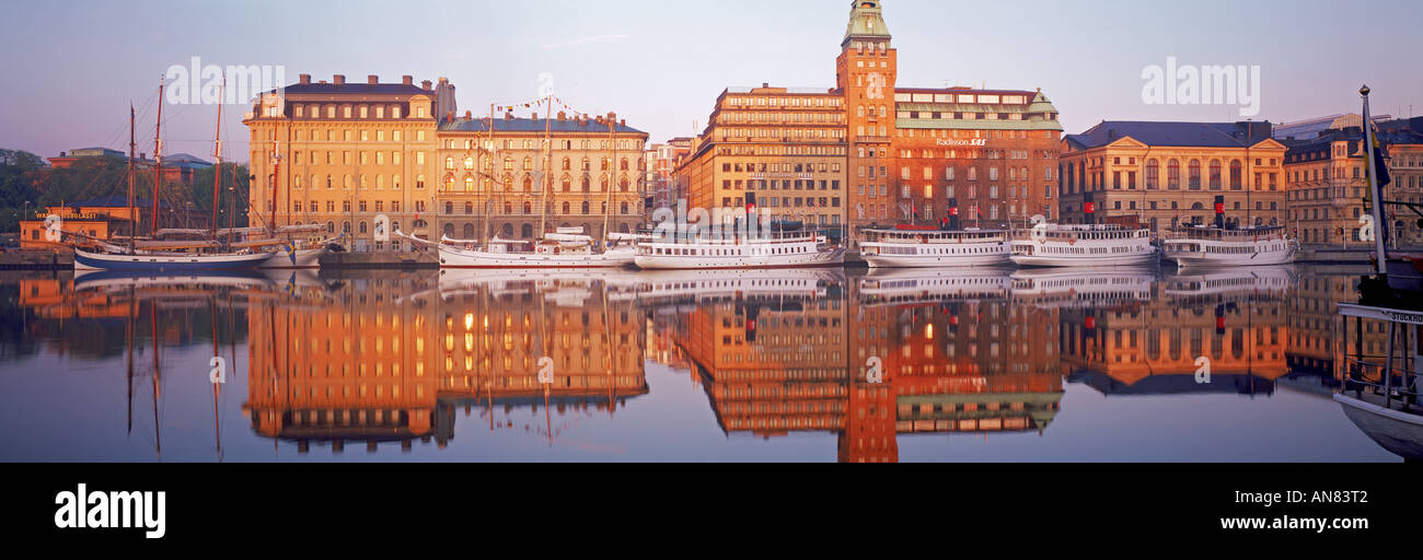 Fähren und Schiffe vertäut am Nybroviken mit SAS Radisson Hotel bei Sonnenaufgang in Stockholm Stockfoto