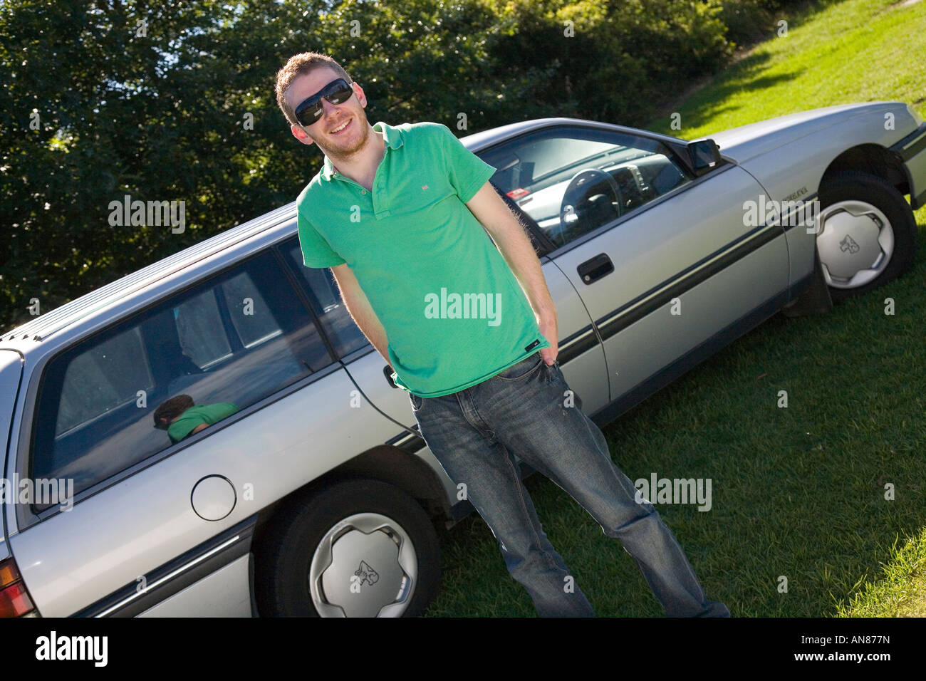 junger Mann Jugend neben seinem Auto stehen mit Stockfoto