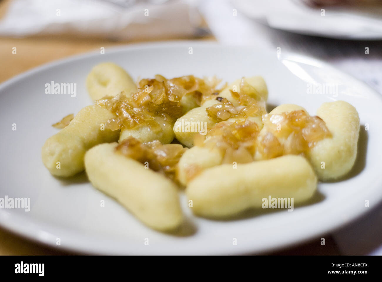 Kartoffelknödel serviert mit karamellisierten Zwiebeln in einem Café in Prag. Stockfoto