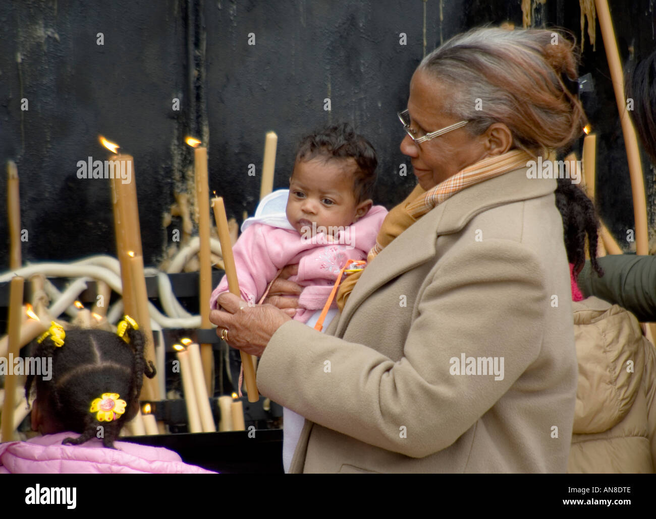 FATIMA PORTUGAL Black Woman mit Enkelkind Licht Kerze für ihre speziellen Anliegen an diesem weltberühmten Wallfahrtsort Stockfoto