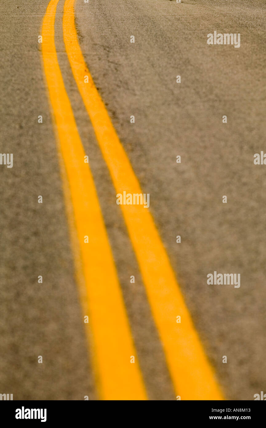 Eine Kurve in der Straße, die durch doppelte gelbe Linien gekennzeichnet Stockfoto