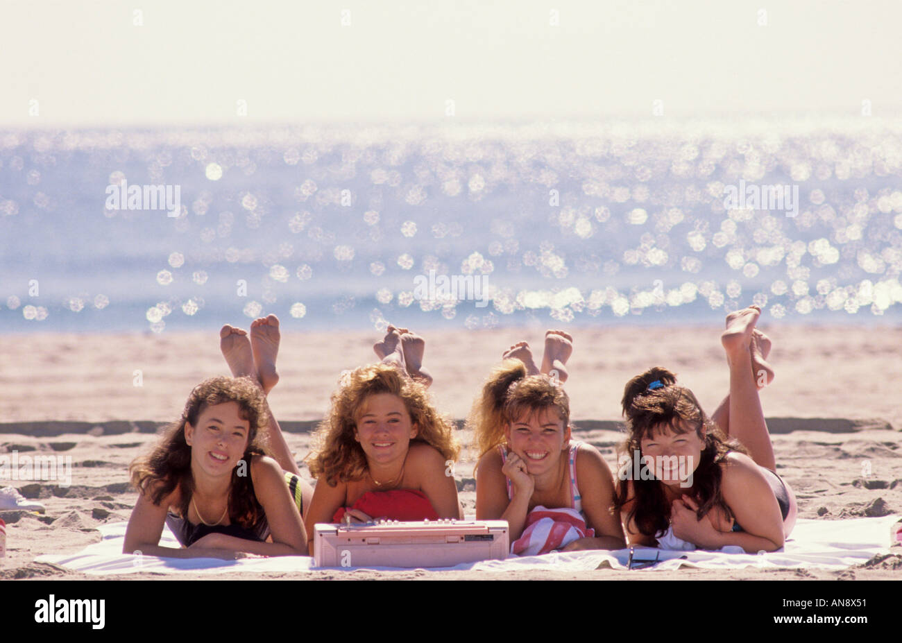 Vier Teenager Frauen bekommen eine tan auf Sand Hampton Beach New Hampshire Stockfoto