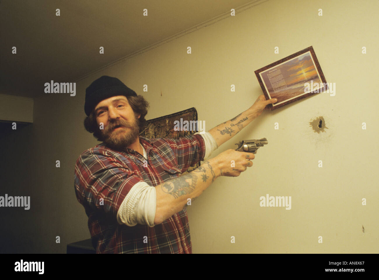 Mann mit Gewehr zeigt Einschussloch legte er in Portsmouth (New Hampshire) Wand Stockfoto