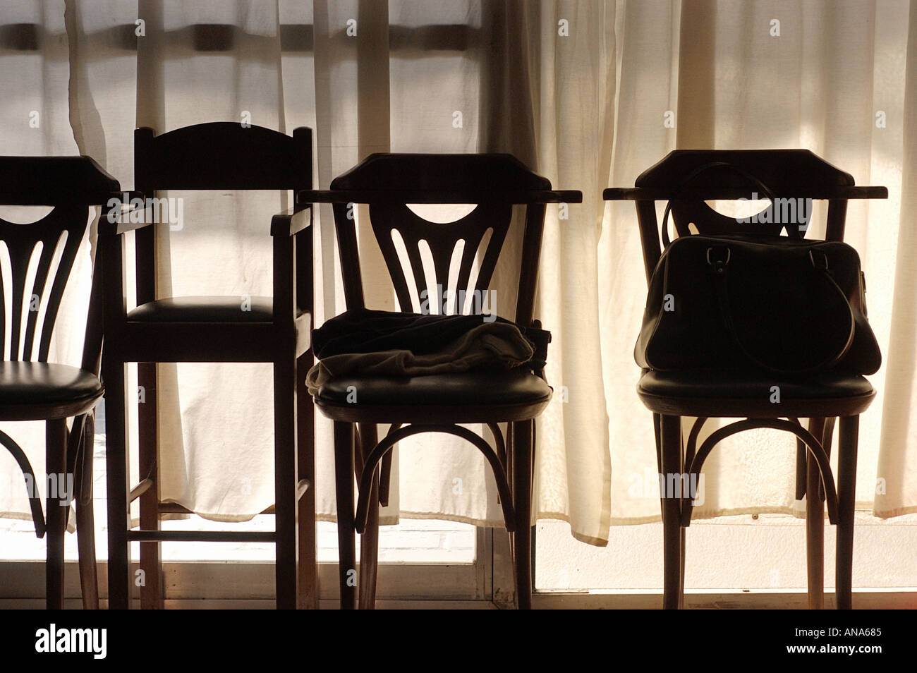 unterschiedliche Stühle gegen Licht Stockfoto