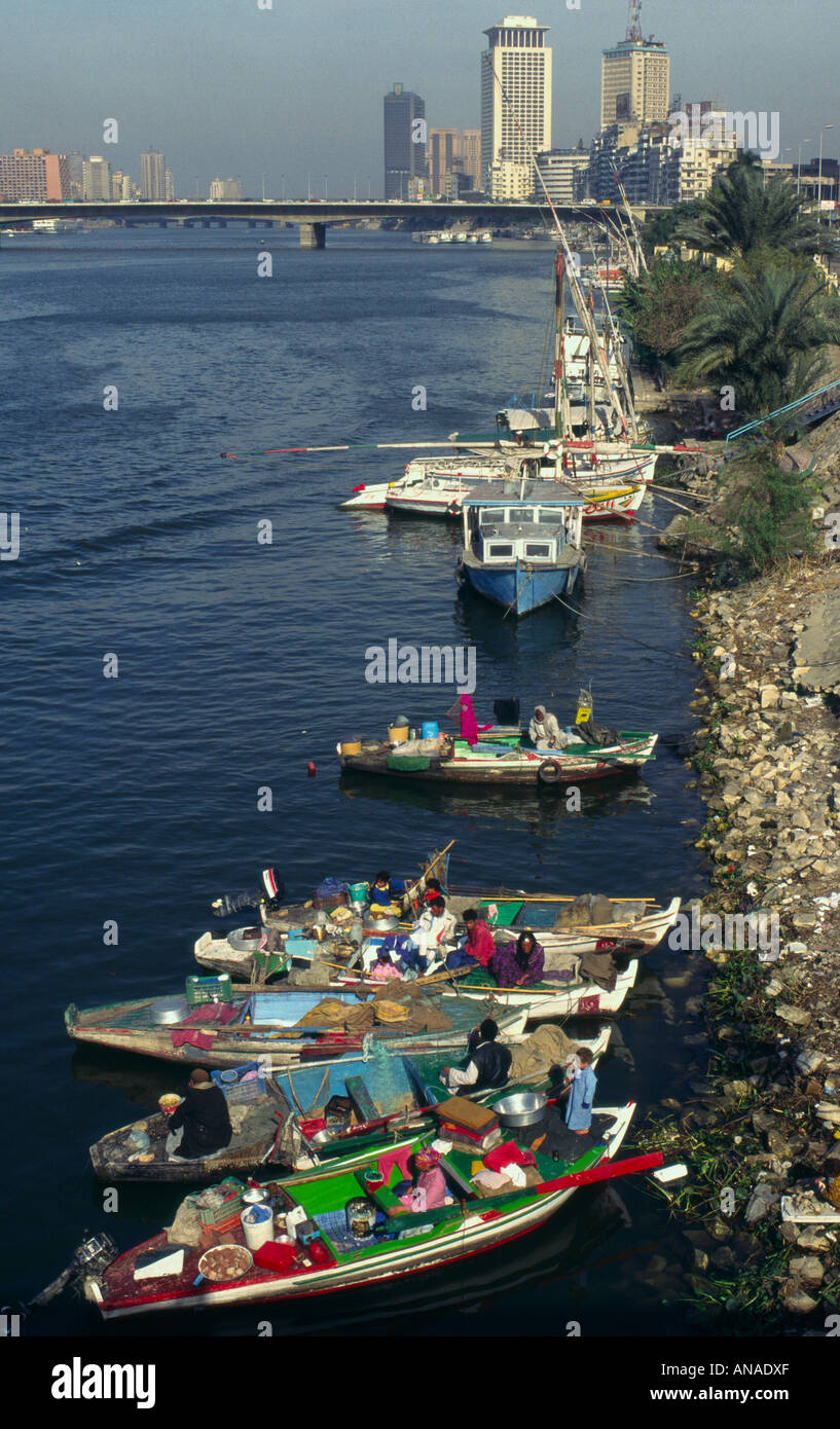 Ägypten Kairo Nil Flussblick von einer Brücke mit armen Menschen leben auf kleinen Booten im Frgd und City Center Tower in bkgd Stockfoto