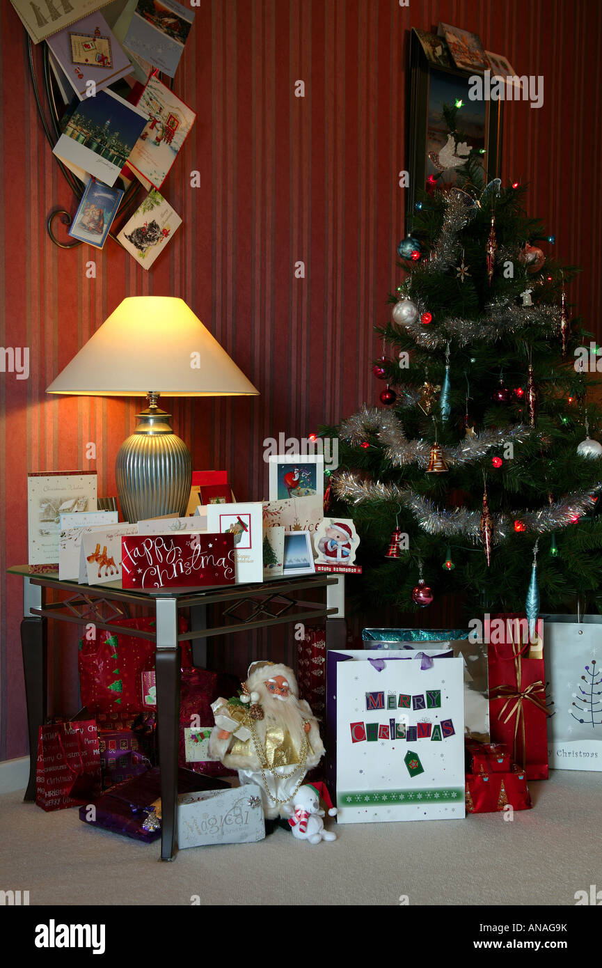 Weihnachtsszene mit geschmückten Baum, Karten an der Wand und Tisch mit Geschenken auf dem Boden Stockfoto