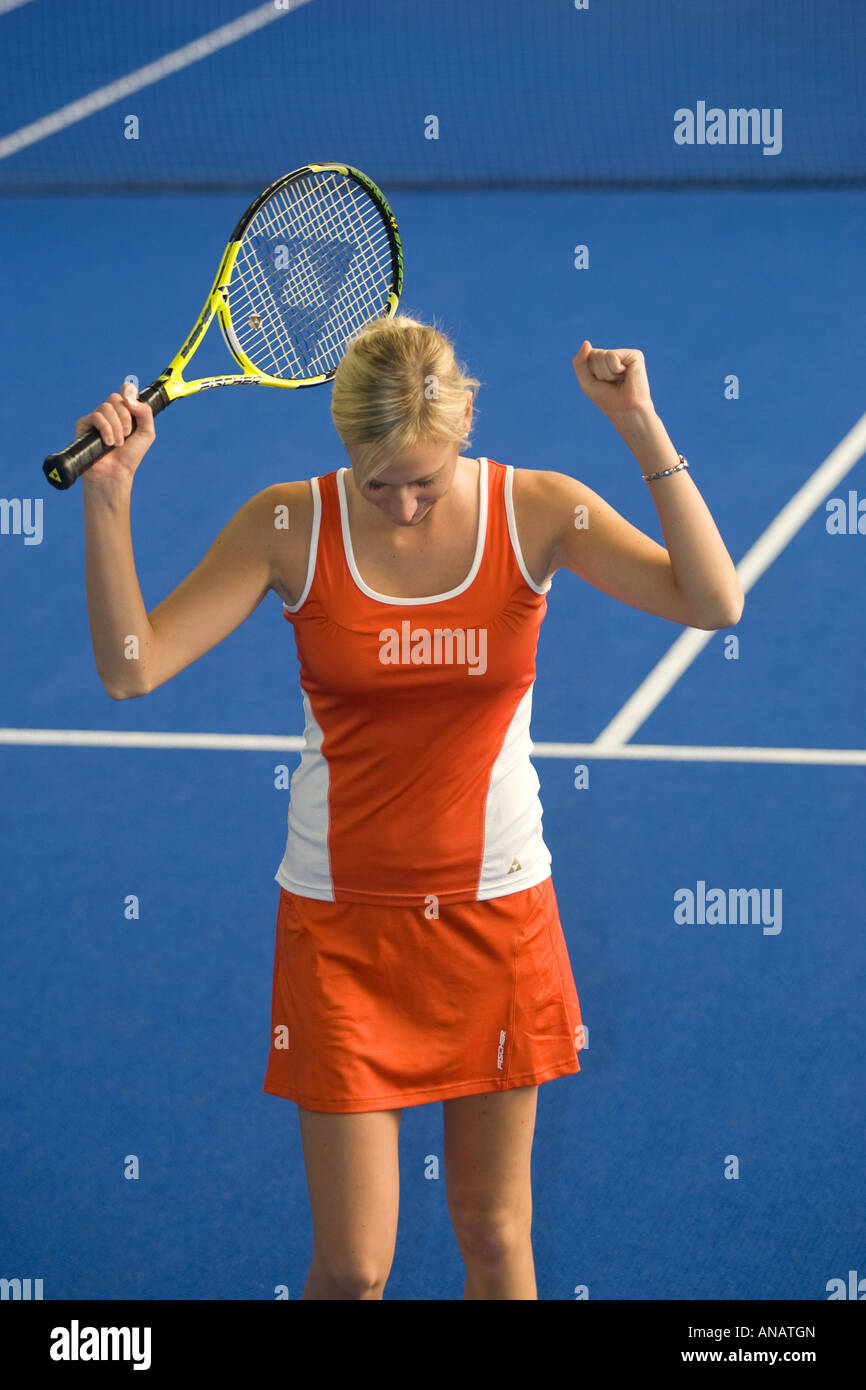 Frau in rot Sportbekleidung indoor Tennis spielen Stockfoto