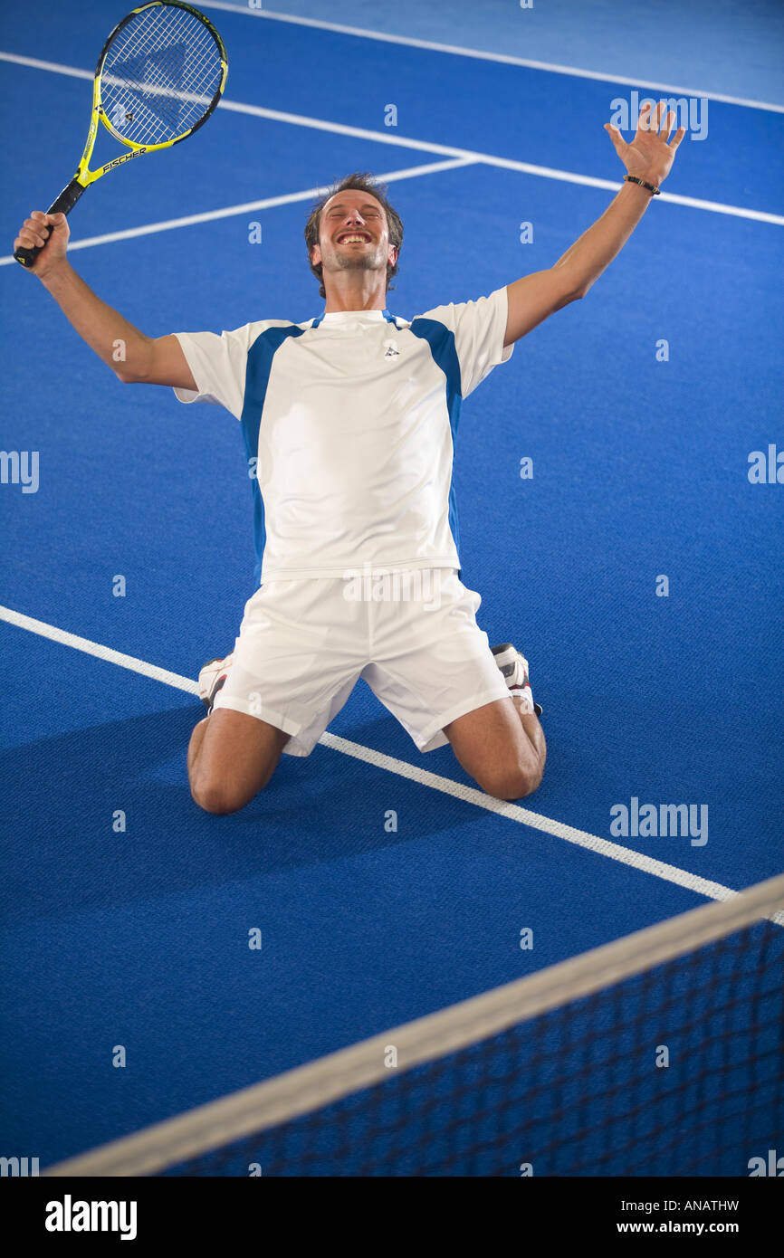 Mann in der weißen Sportswear indoor Tennis spielen Stockfoto