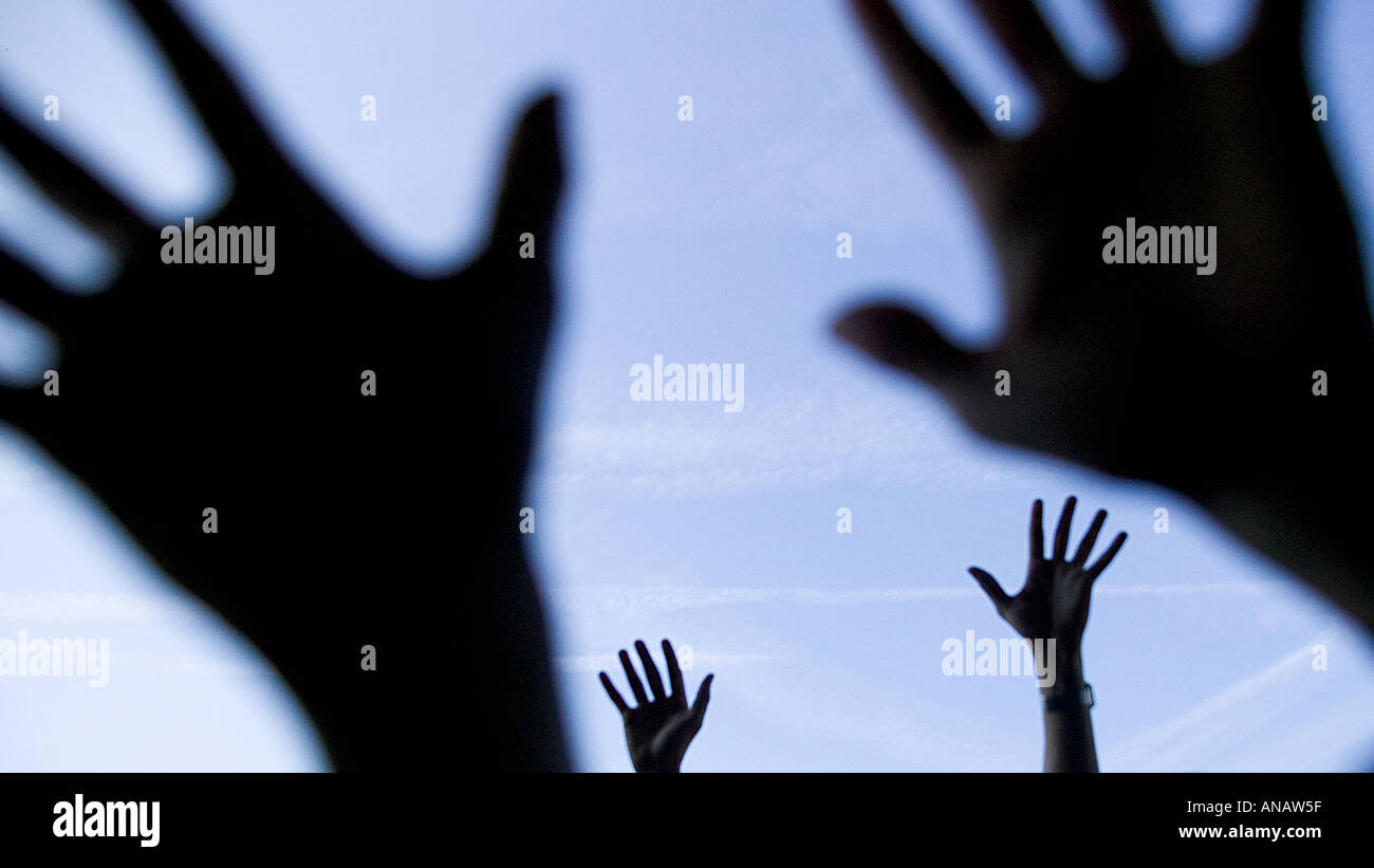 Silhouette von zwei paar Hände winken beim Musikfestival mit blauen Himmel im Hintergrund Stockfoto