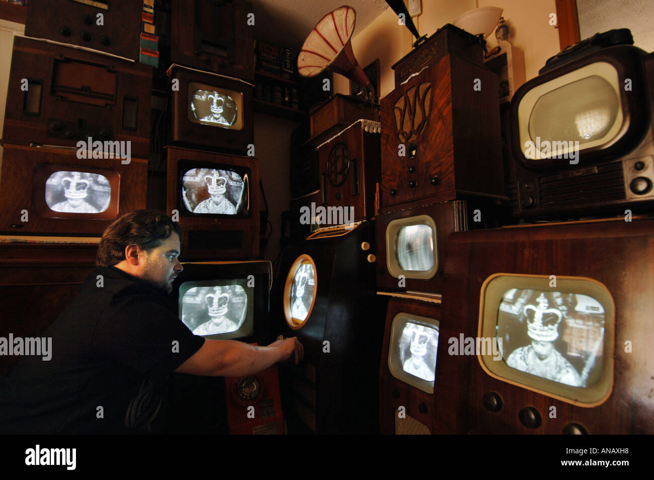 Alte TV-Sammler Peter Carlton Melodien eines seiner 14 Jahrgang tvs zu einem Video der Krönung von Queen Elizabeth 11 Stockfoto