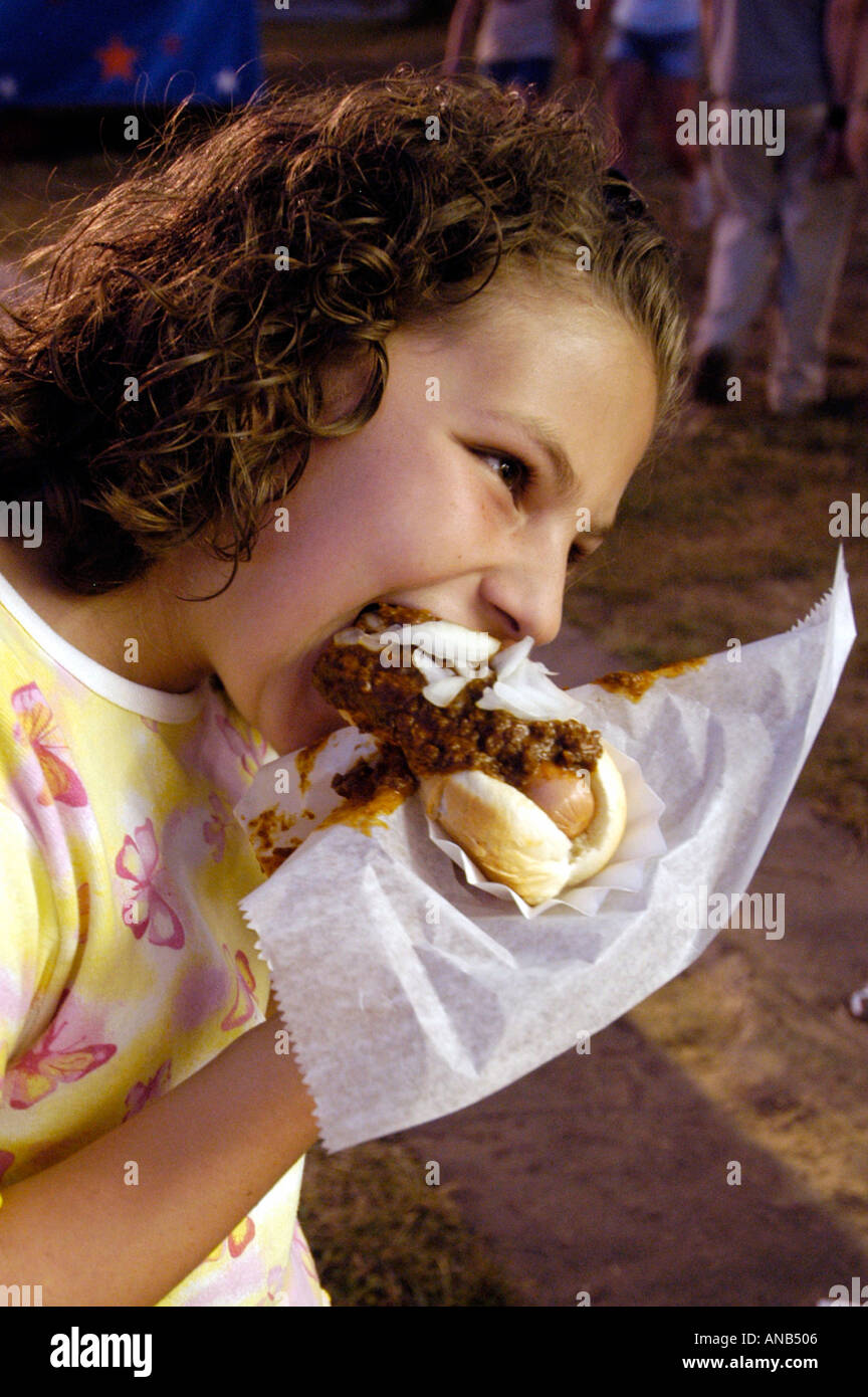 Zehn Jahre alten Mädchen isst Chili Hund beim Festival Stockfoto