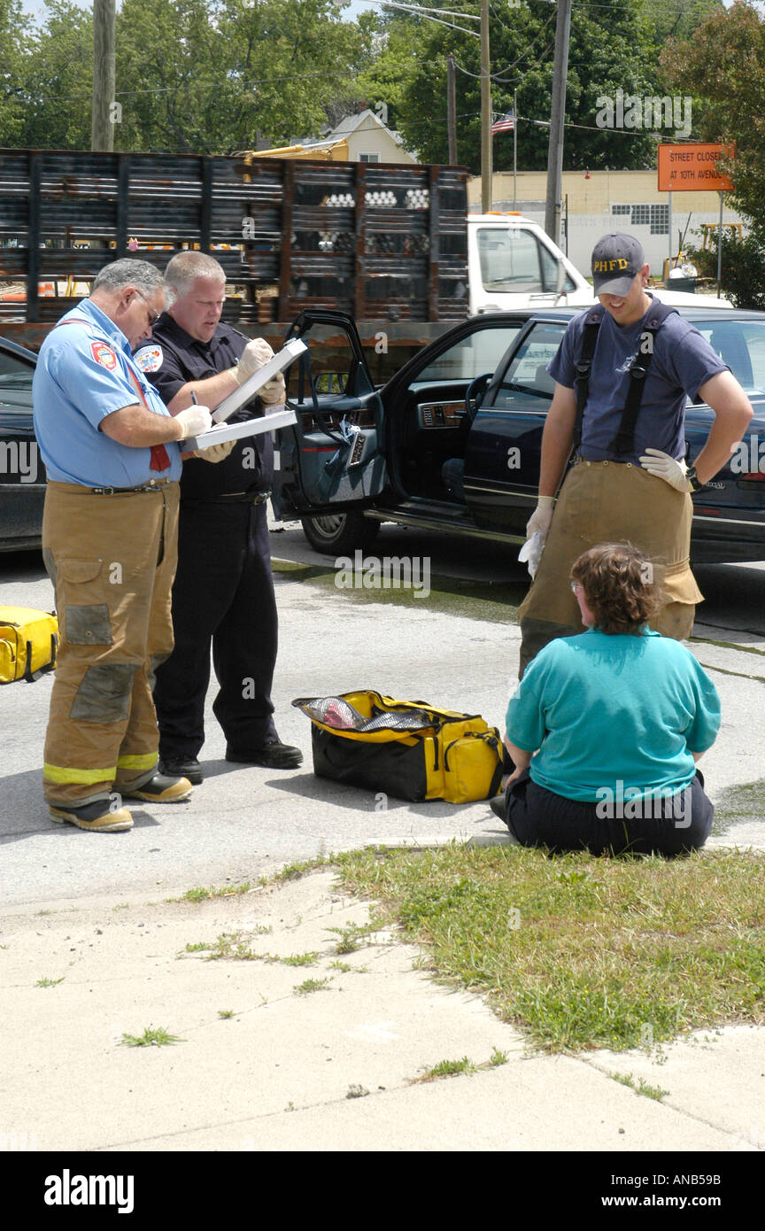 Notfall Arbeiter helfen weibliche Opfer im Auto Auto Auto Unfall Stockfoto