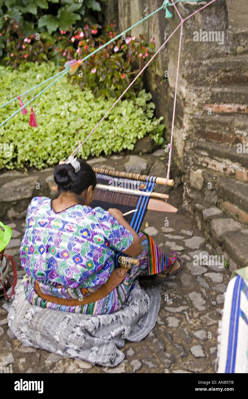 GUATEMALA ANTIGUA Cakchiquel Maya-Frau trägt traditionelle Huipil und Corte mit einem Backstrap Loom um zu weben von Textilien Stockfoto