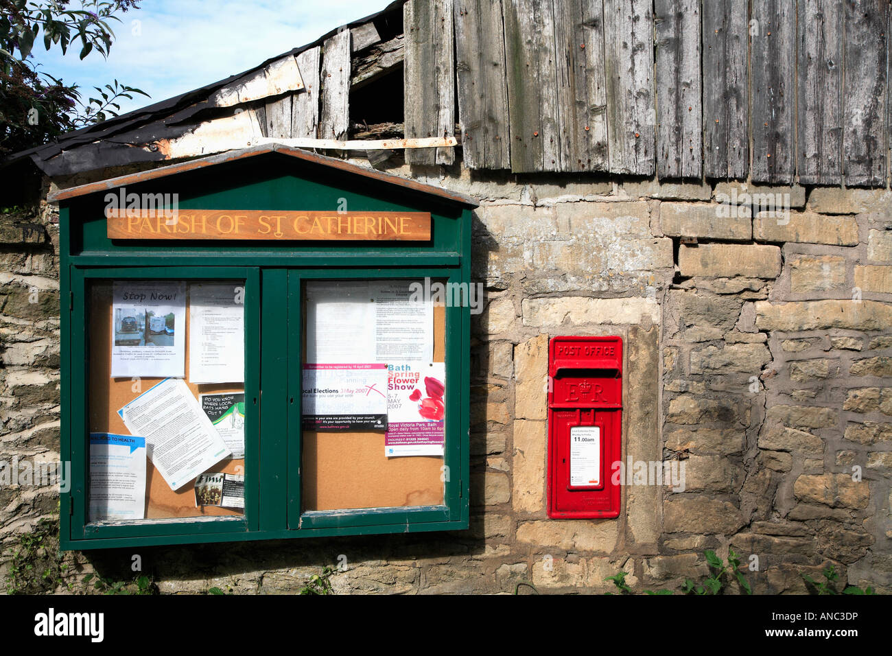 Dorf Pfarrei Schwarzes Brett und roten Briefkasten in Steinmauer Stockfoto