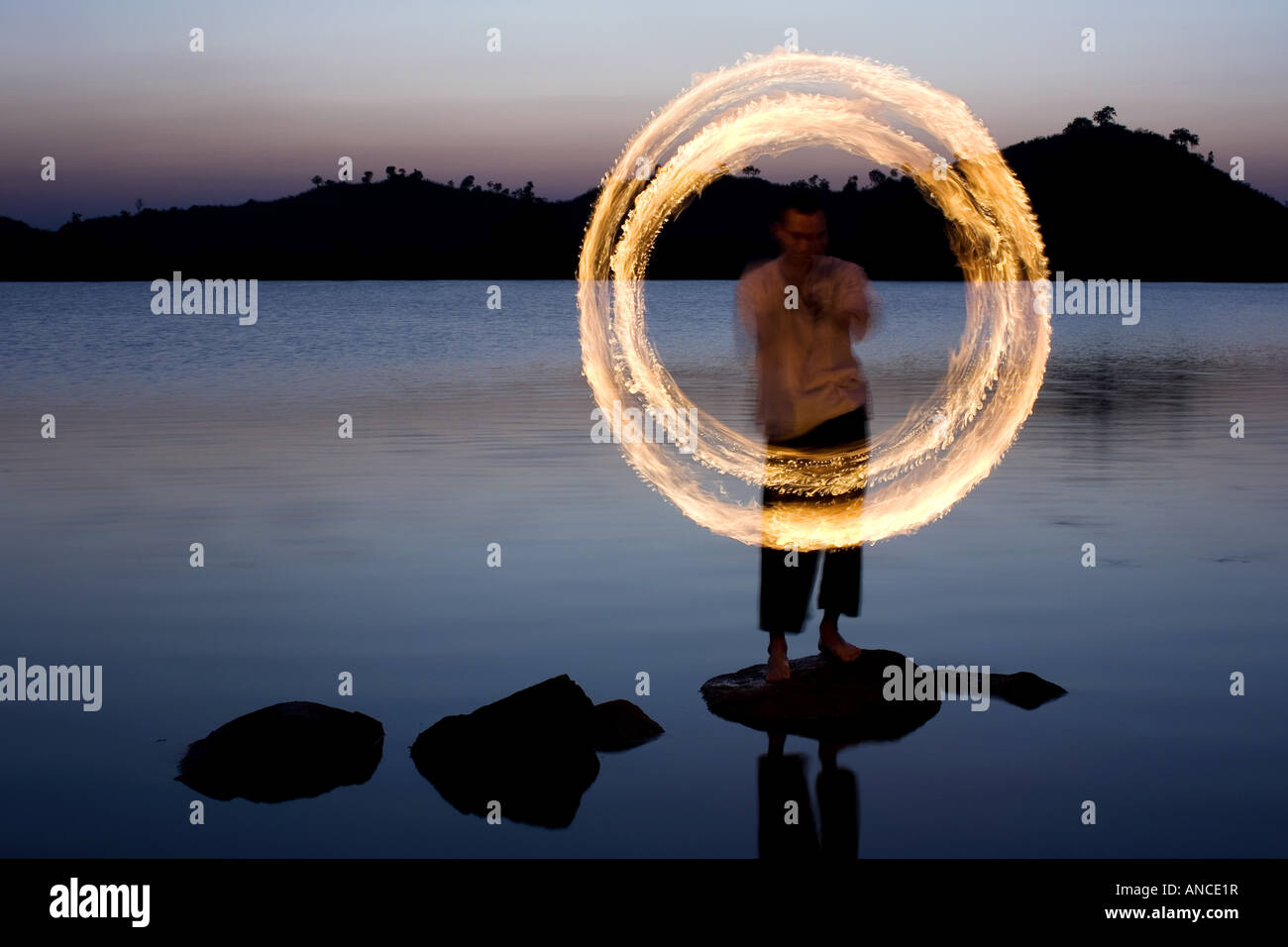 Menschen das Feuer tanzen auf einem Felsen in einem See in Indien Stockfoto