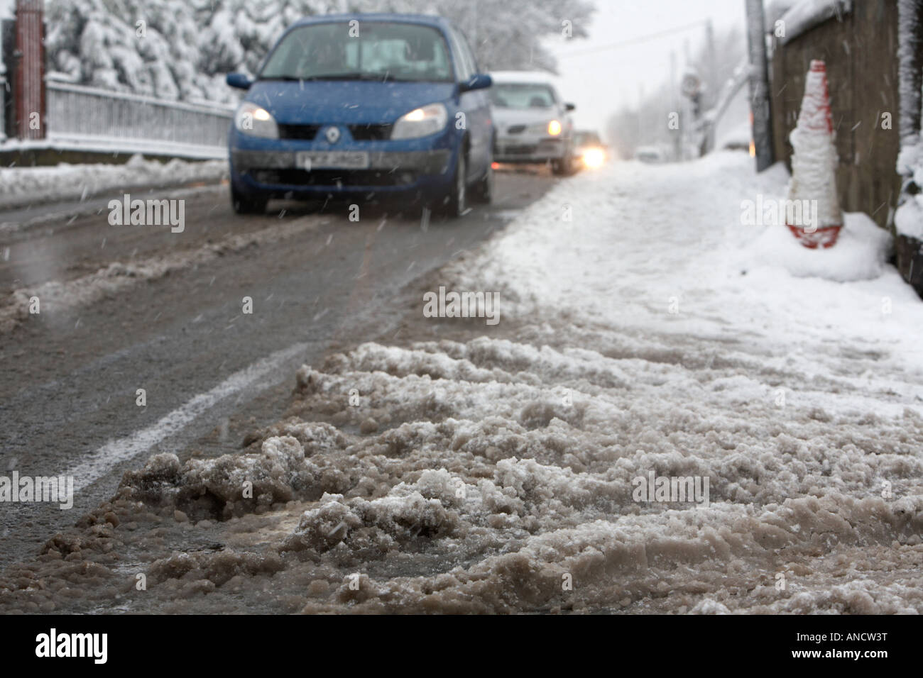 Matsch, Schneeschmelze, Aufbau von der Seite der Straße, wie Autos vorbei fahren Stockfoto