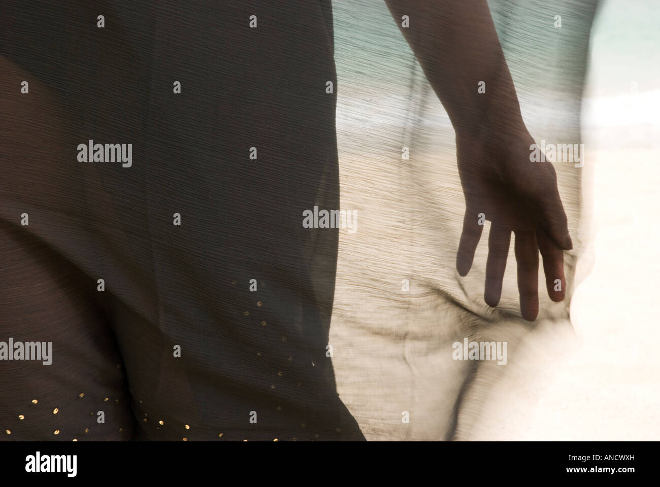 Ein Farbbild Landschaft die Hand einer Frau durch einen Sarong, welche im Wind weht. Stockfoto