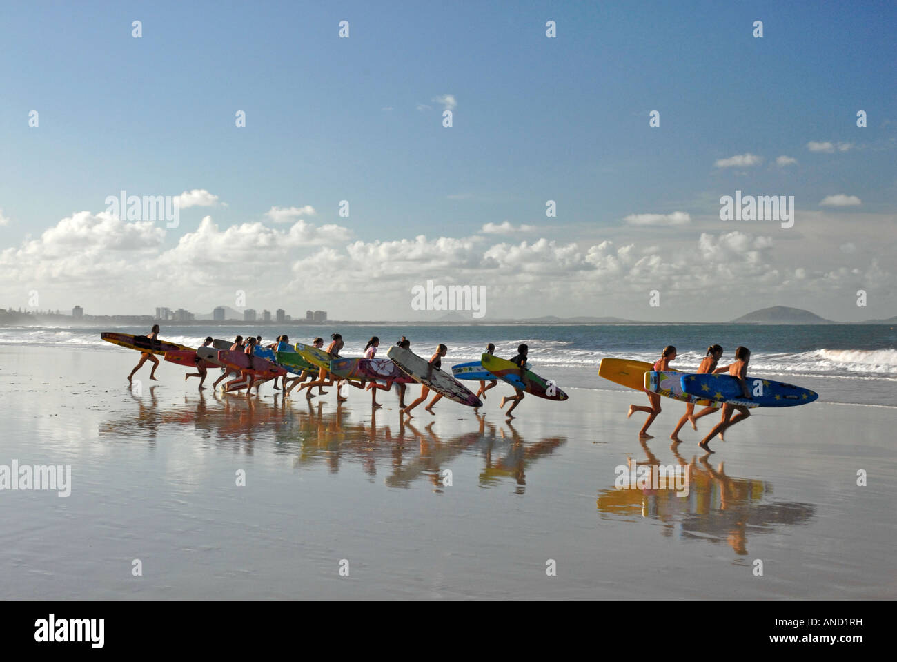Gruppe von Surfern tragen Surfbretter hinunter in Richtung Meer Stockfoto