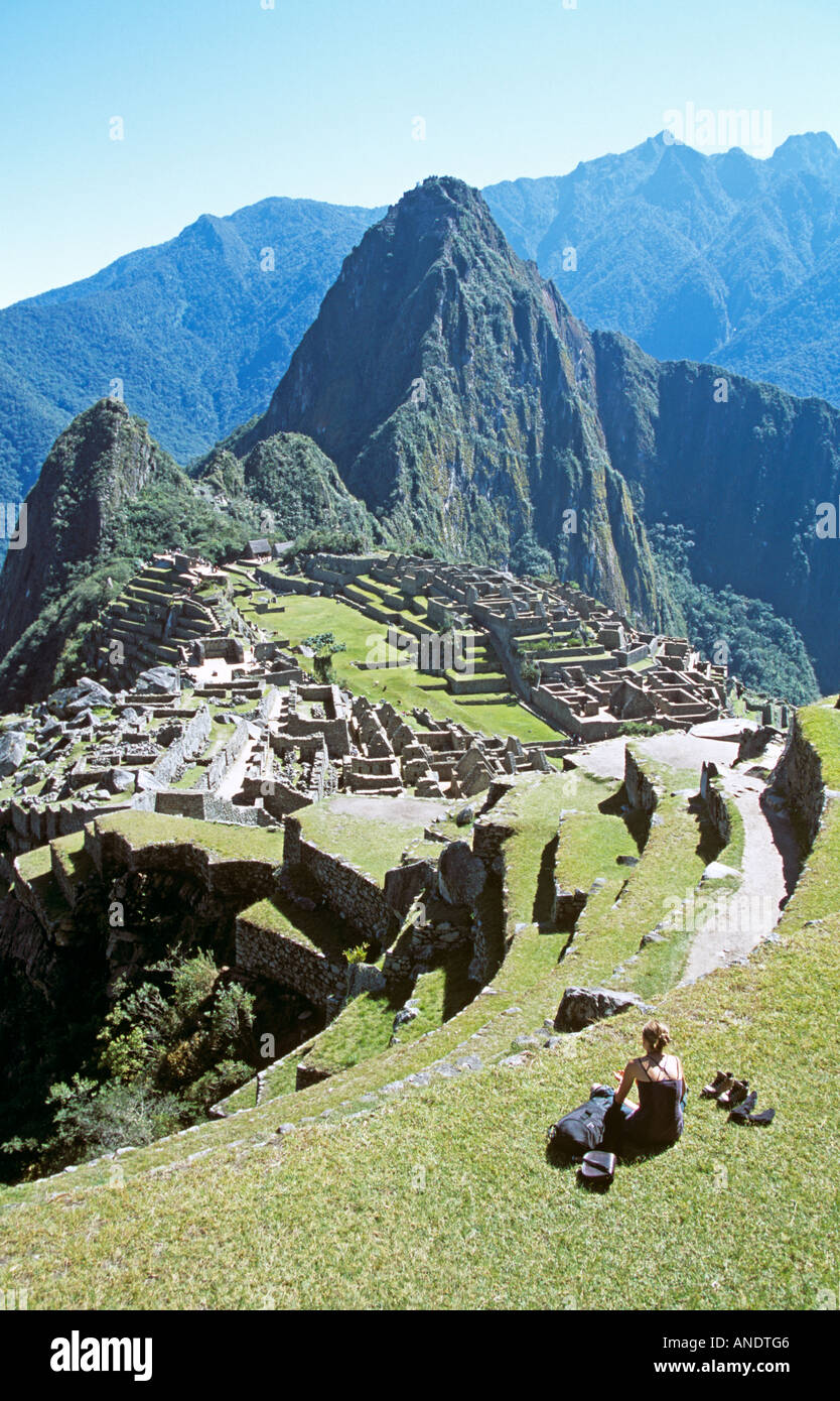 Inkaruinen Machu Picchu, Terrassen, Besucher auf der Terrasse sitzen und Huayna Picchu, Peru Stockfoto
