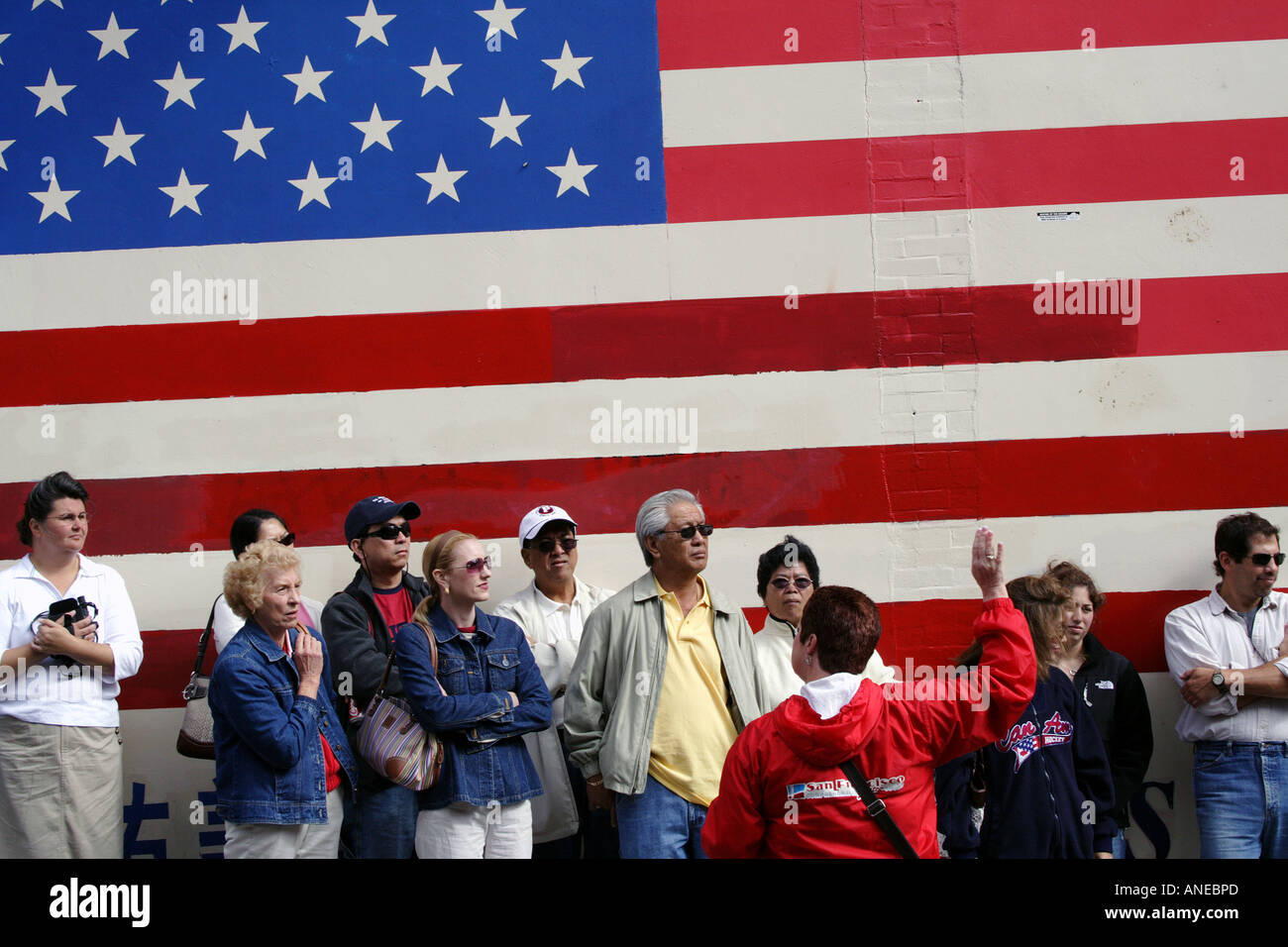 Ein Enthnically Diverse Reisegruppe vor einer großen amerikanischen Flagge, San Francisco, Kalifornien Stockfoto