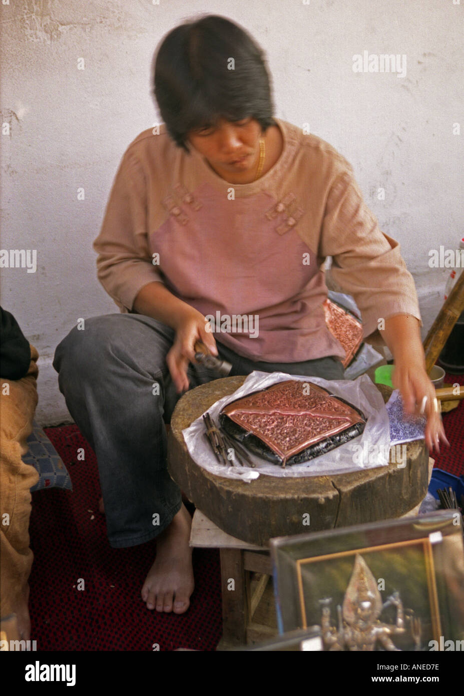 Indigene Frau sitzen im freien Arbeit schmücken geduldig Kupfer Handwerk auf Holz-Plattform Kuala Selangor Malaysia Südost-Asien Stockfoto