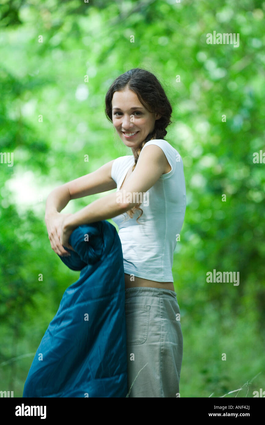 Junge Camper zusammenrollt, Schlafsack, lächelnd in die Kamera Stockfoto