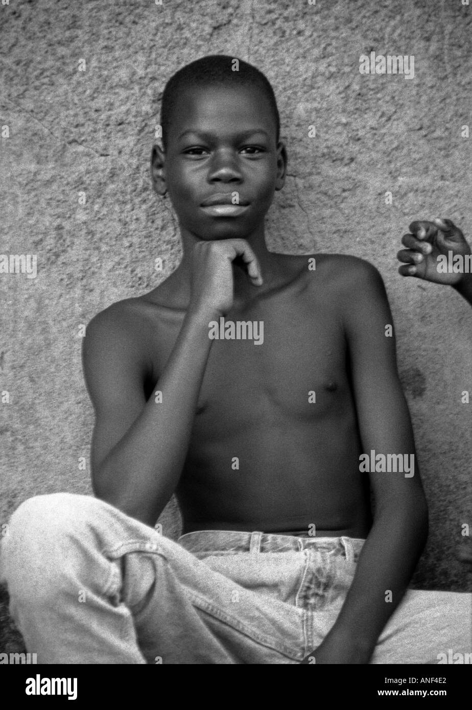 Porträt Lächeln Jugendliche Elendsviertel Acholy Quartal posiert im freien außerhalb Wand Schlamm Hütte Kampala-Uganda-Ost-Afrika Stockfoto