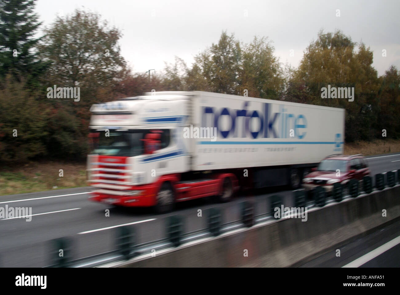 Motion Blur bild Sattelschlepper Fahren mit hoher Geschwindigkeit mit dem Auto vorbei fahren entlang der französischen Autobahn Route zwischen Calais und Paris. Stockfoto