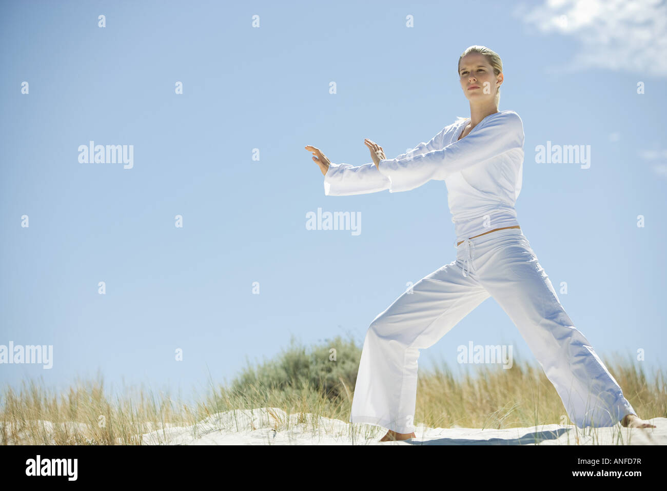 Junge Frau Tai Chi in Dünen, in voller Länge zu tun Stockfoto