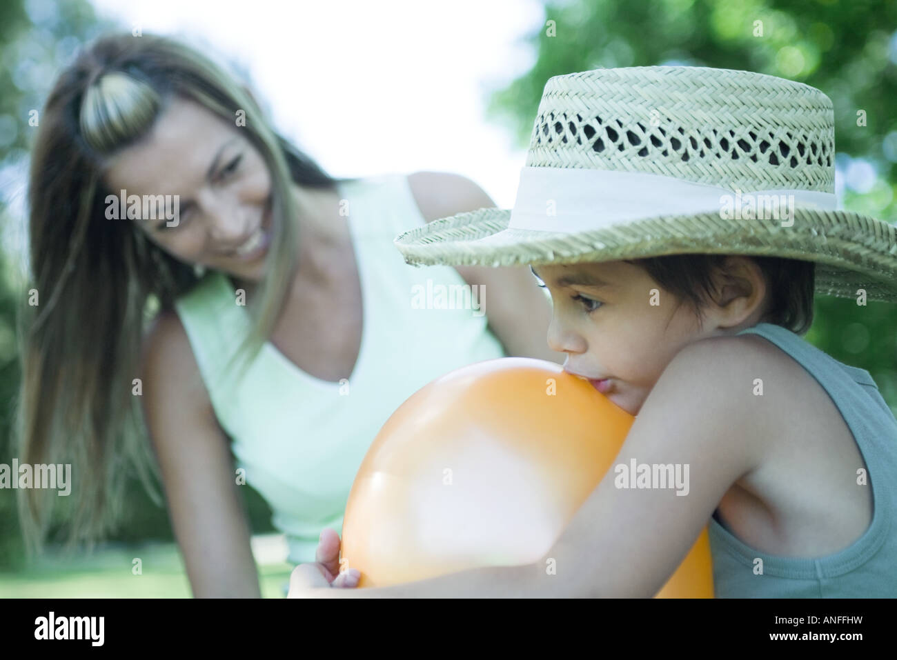 Mutter und Sohn, Uhren junge Sprengung Ballon während Mutter Stockfoto