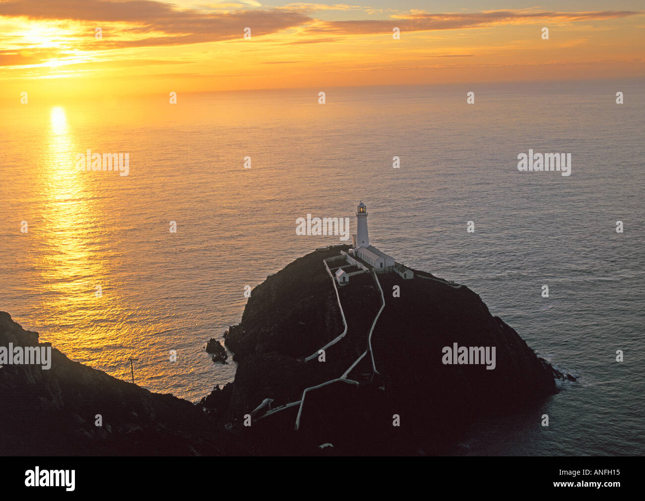 HOLYHEAD ISLE OF ANGLESEY NORTH WALES UK die Sonne geht hinter dem South Stack Leuchtturm erbaut im Jahre 1809 auf Ynys Lawd Stockfoto