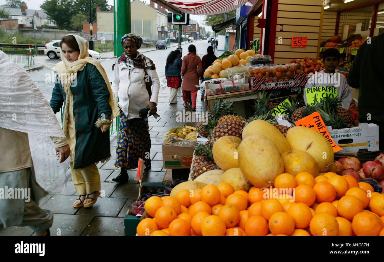Asiatische und Afro-Karibische Frauen passieren von Obst und Gemüse laden im Bereich Lozells Birmingham UK Stockfoto
