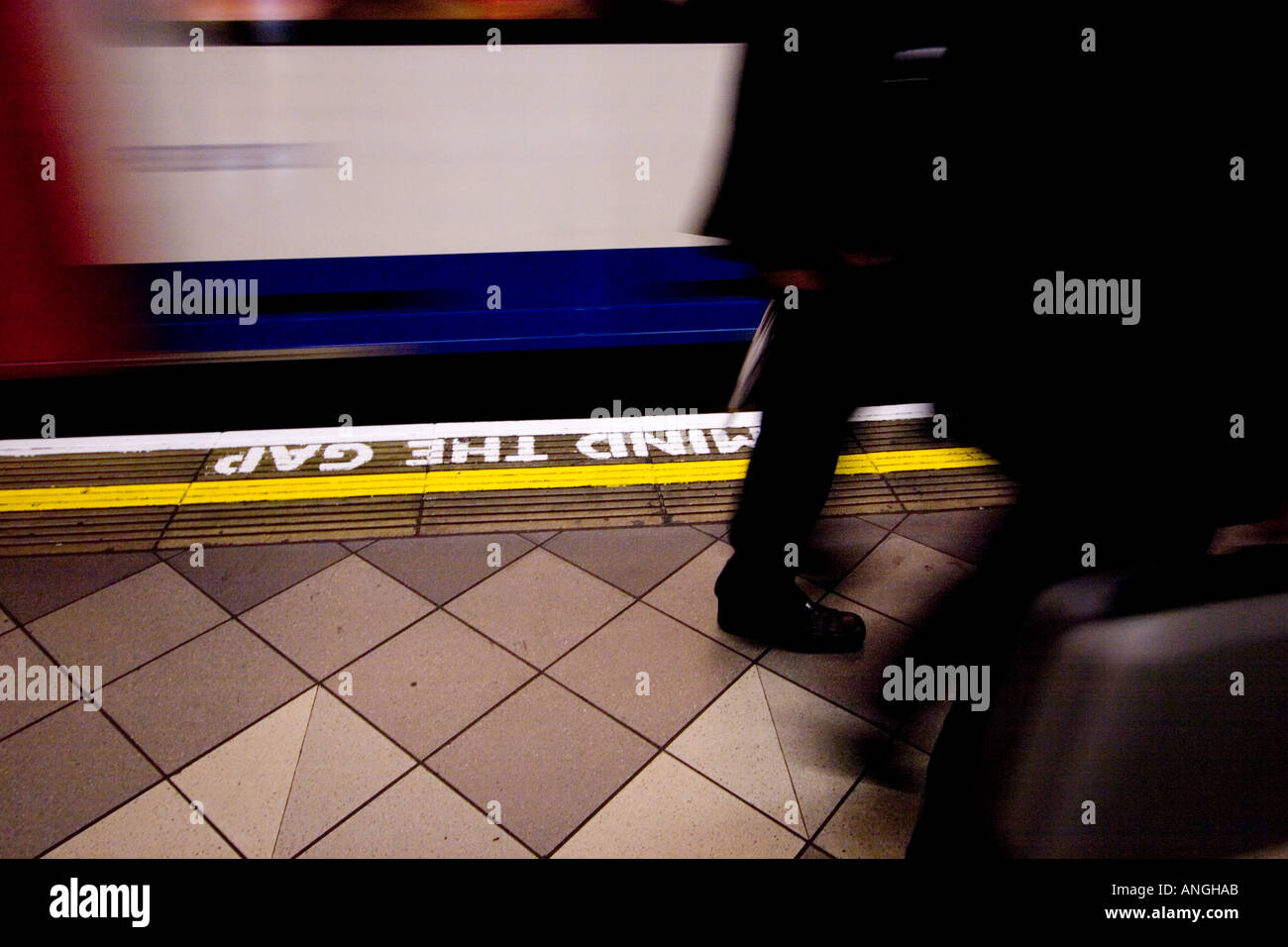 Pendler, die vorbei an Beschleunigung Rohr trainieren auf Londons u-Bahn-Netz mit Verstand die Lücke Zeichen auf Plattform lackiert Stockfoto