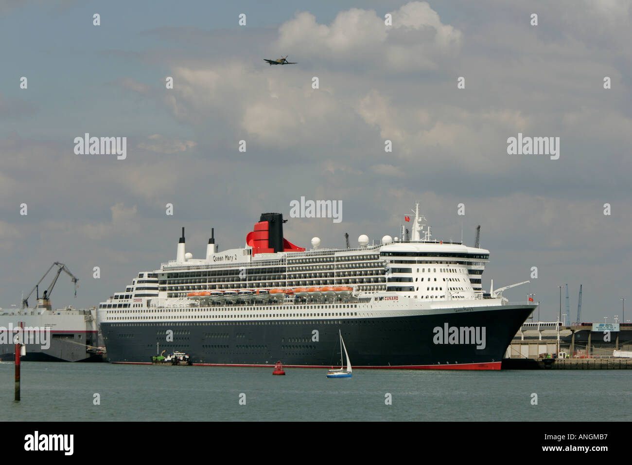 die Queen Mary wird die zweite overhead einer Spitfire in Southampton Docks übergeben Stockfoto