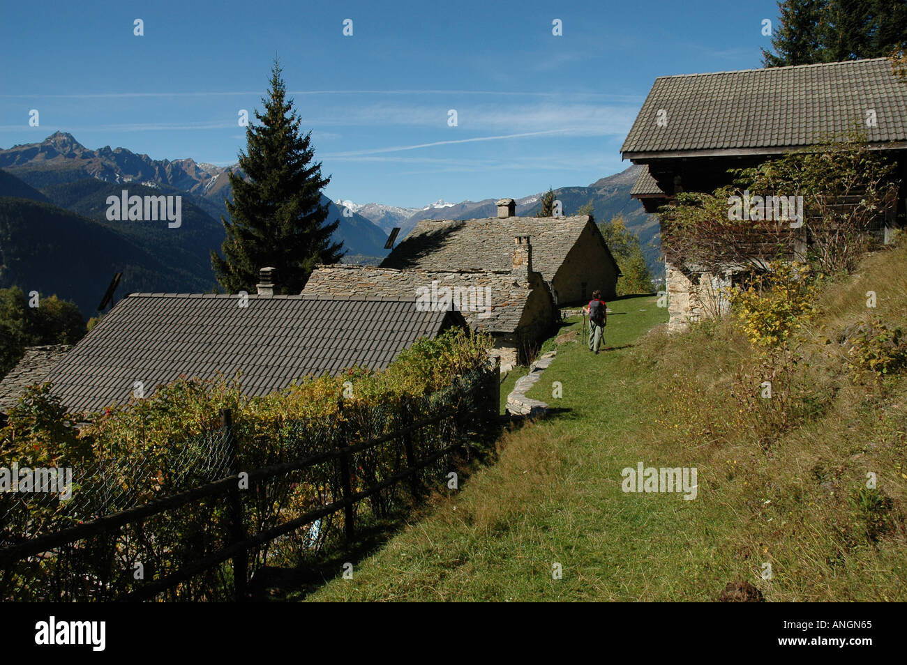 Wanderer führt durch alte Häuser bei Alp Co Strada Alta Kanton Tessin Ticino Schweiz Stockfoto