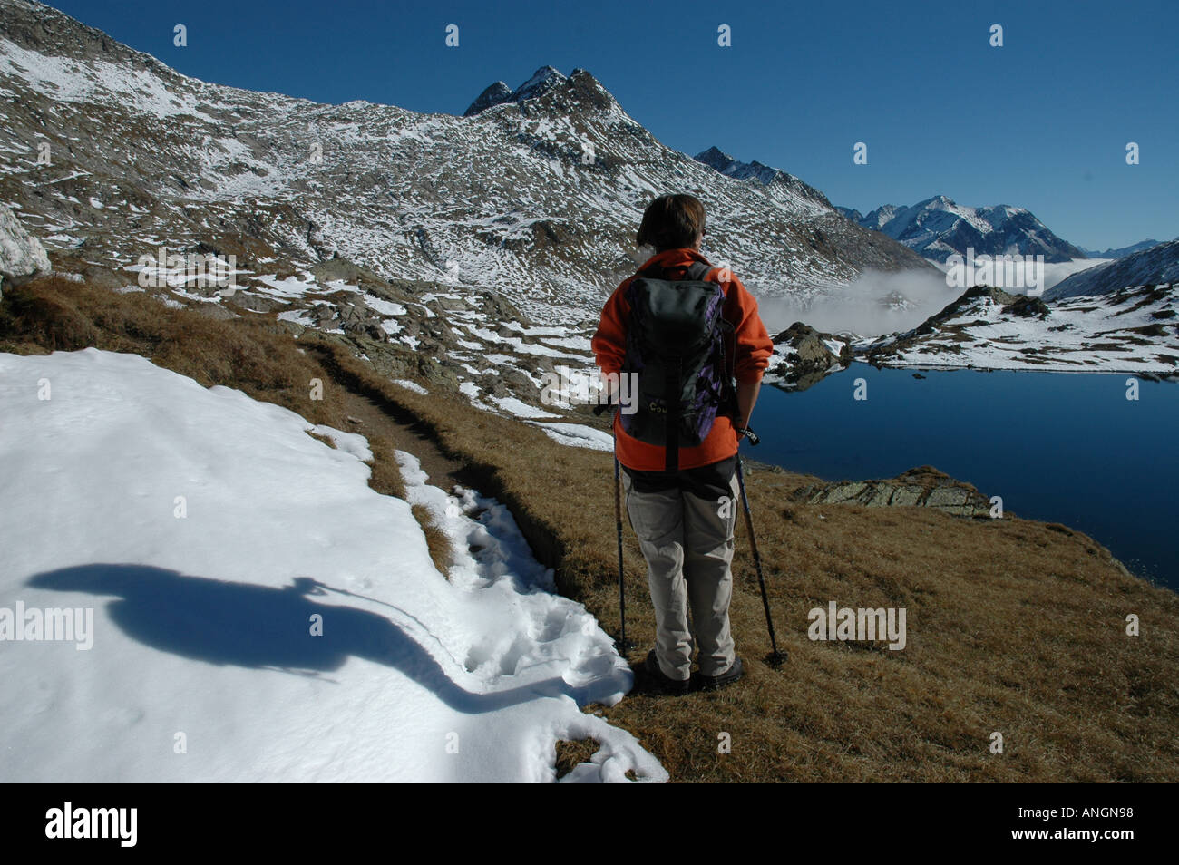 Wanderer am See Lago di Dentro Cadlimo Herbst erste Schneefall Tessin Tessiner Alpen Schweiz Stockfoto