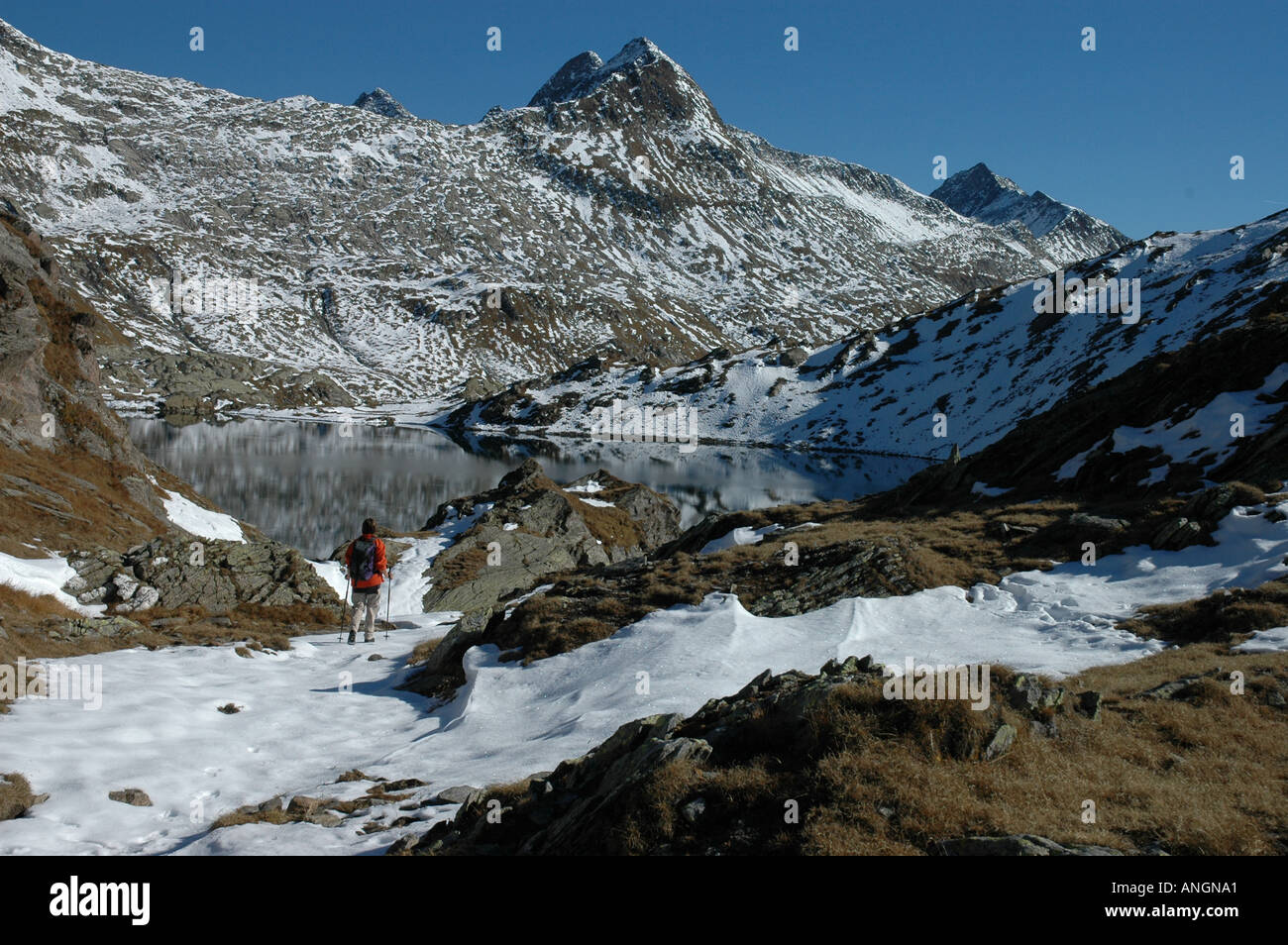 Wanderer geht in Richtung See Lago di Dentro, Cadlimo, Piz Tanalin Herbst Schnee, Tessin Tessiner Alpen Schweiz Stockfoto