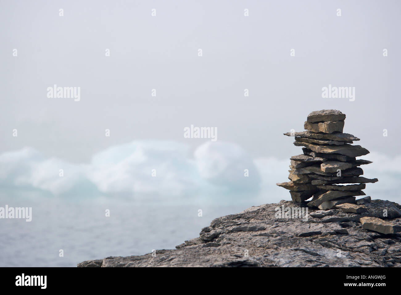 Rock Inukshuk auf einem Felsvorsprung Backdropped von Packeis verschleiert durch Nebel in der Strait Of Belle Isle, Labrador Coastal Drive, Viking Trail Stockfoto