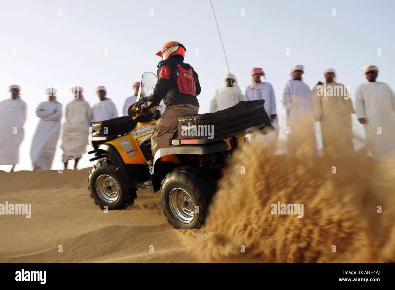 Gruppe von arabischen Männern in der Wüste einen Quad-Fahrer beobachten Stockfoto