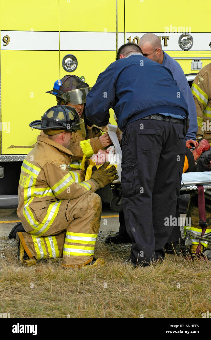 Feuerwehrleute kümmern sich um verletzte Crash-Opfer eines Kopfes auf Automobil Absturz Stockfoto