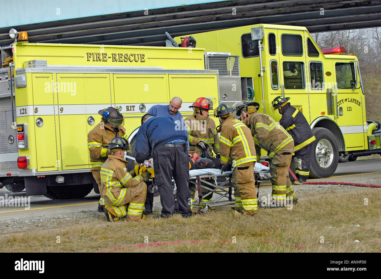 Feuerwehrleute kümmern sich um verletzte Crash-Opfer eines Kopfes auf Automobil Absturz Stockfoto