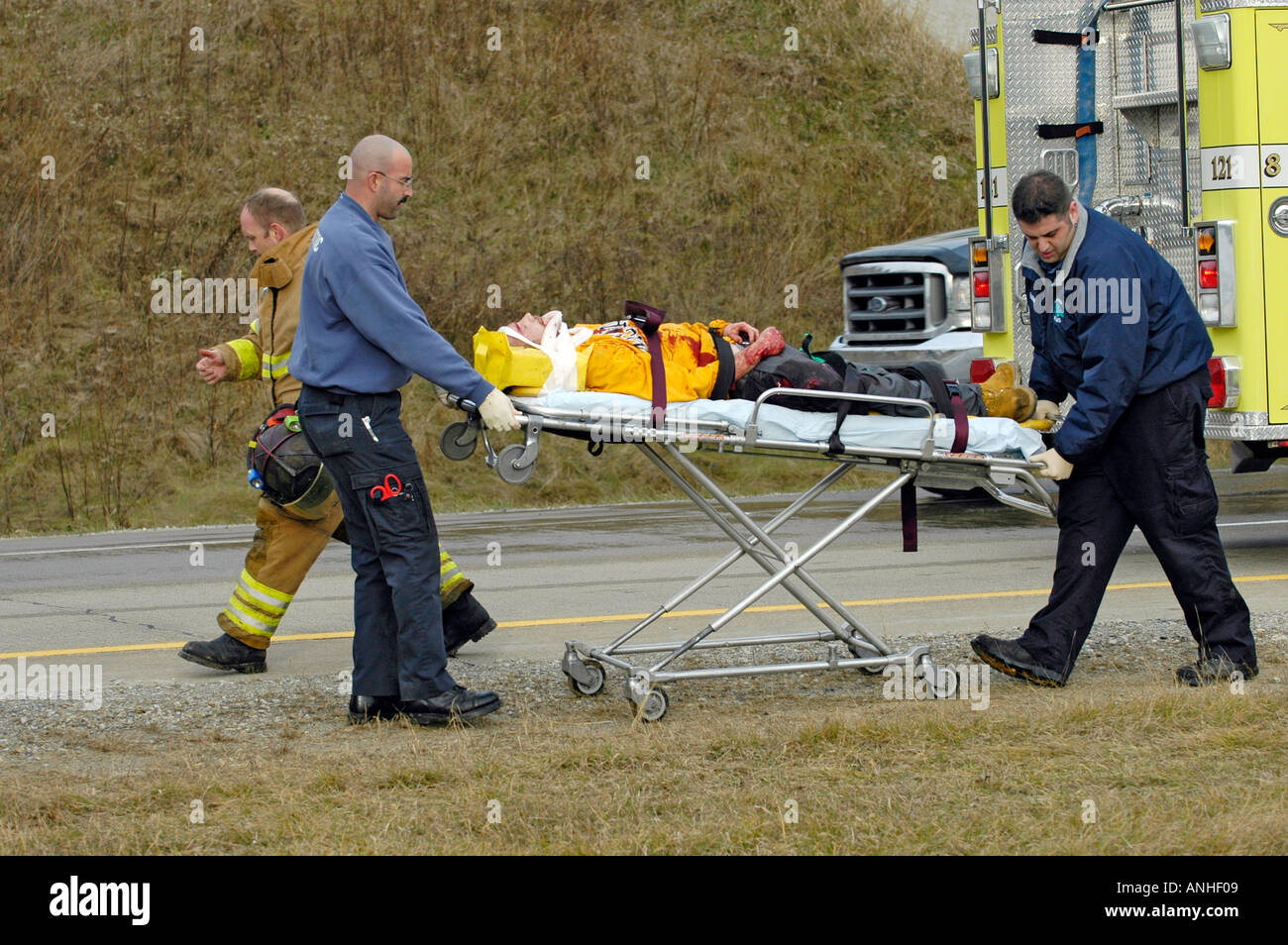 Feuerwehrleute kümmern sich um verletzte Crash-Opfer eines Kopfes auf Automobil Absturz Stockfoto