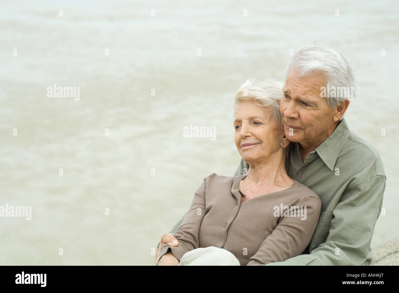 Älteres paar sitzen gemeinsam, Wange an Wange, wegschauen Stockfoto