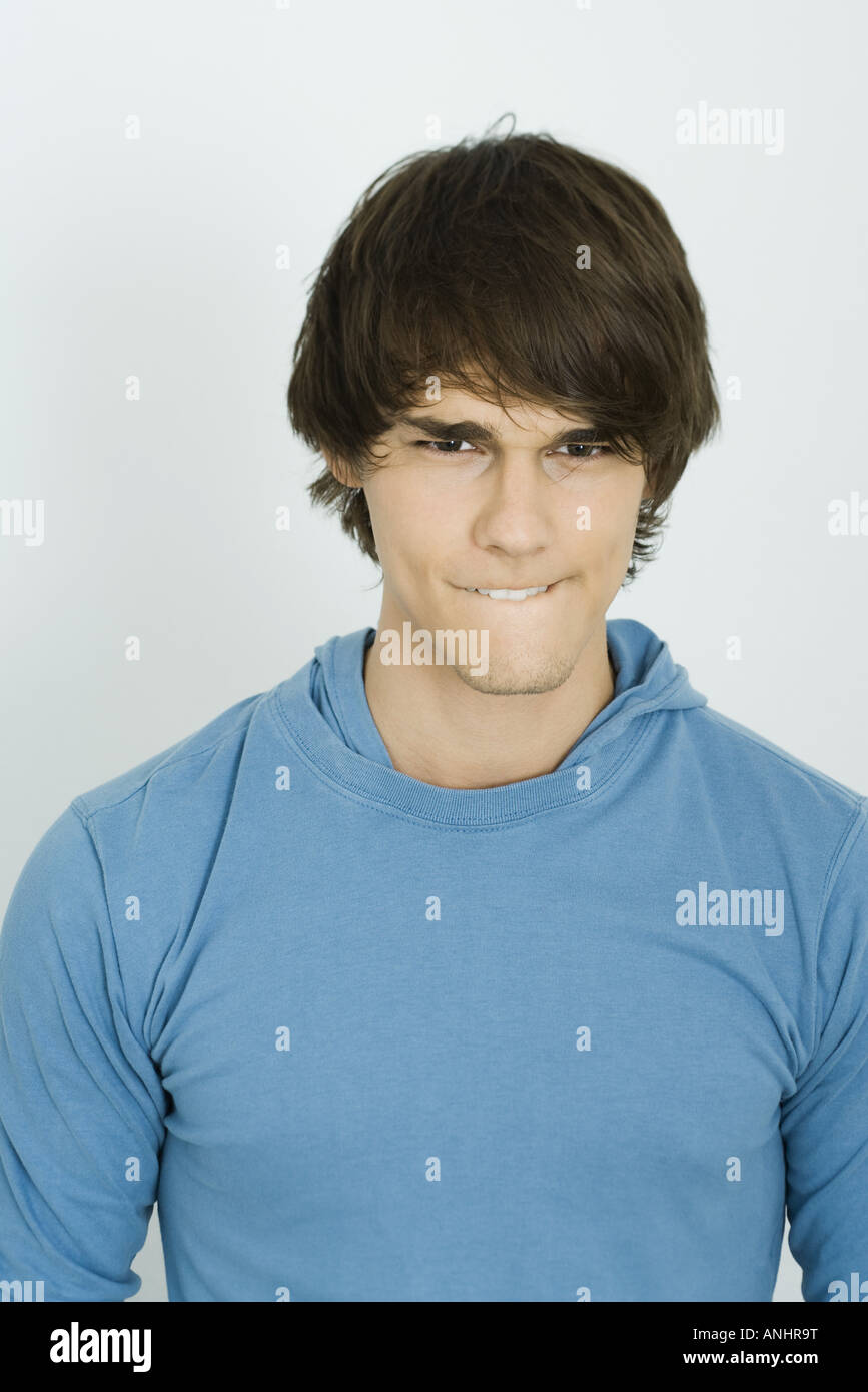 Junger Mann Beisst Lippe Blick In Die Kamera Stockfotografie Alamy