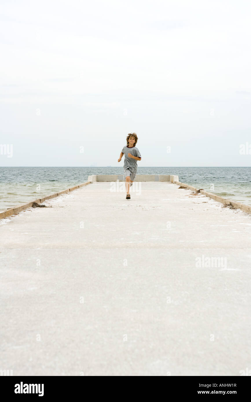 Junge am Pier in Richtung Kamera, Ozean im Hintergrund laufen  Stockfotografie - Alamy