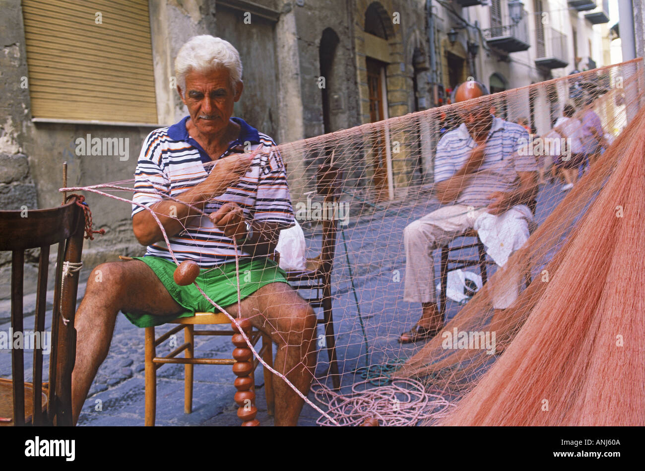 Männer, die Reparatur von Fischernetzen im Dorf von Cefalu auf Sizilien Stockfoto